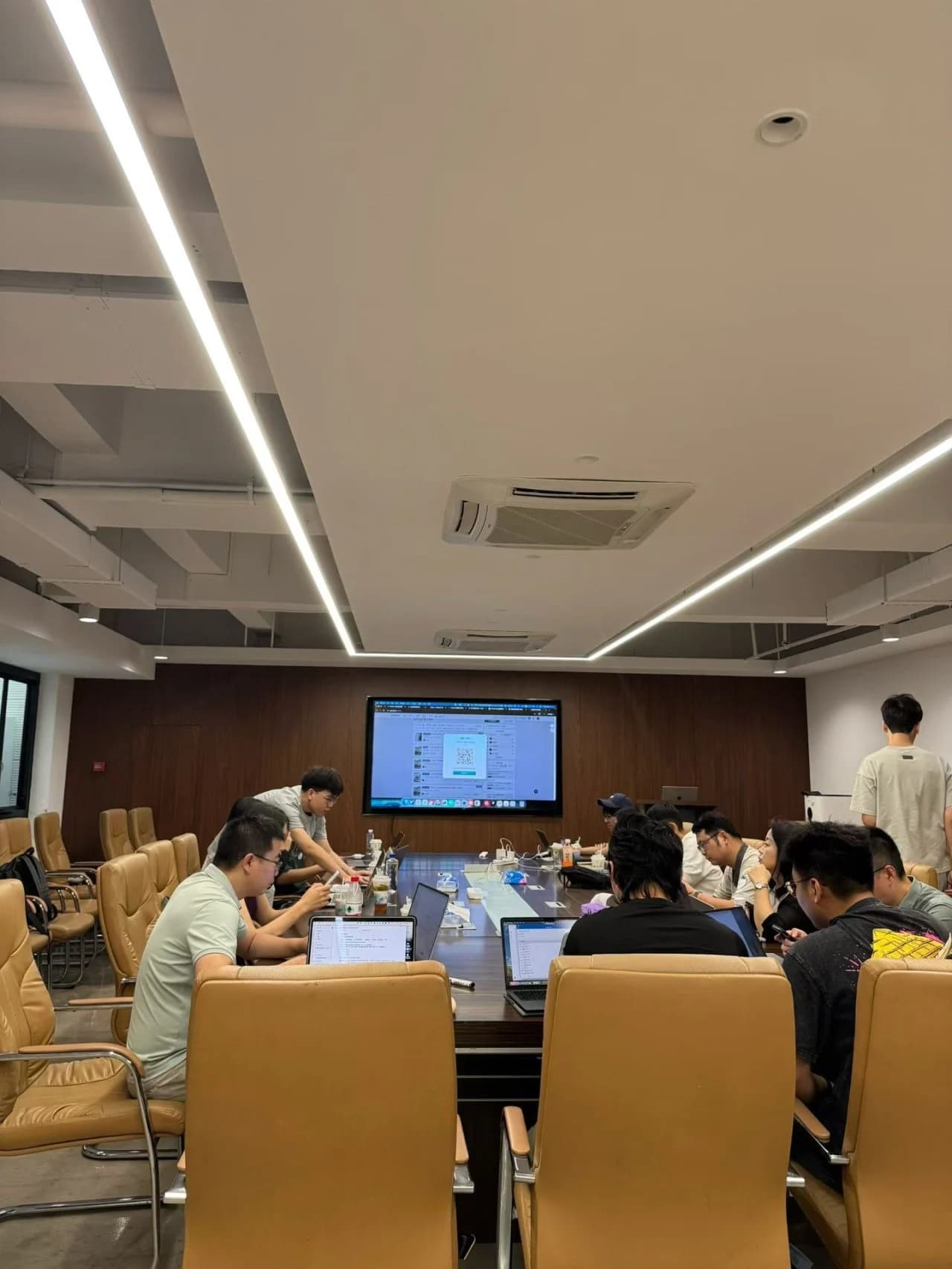 学员围坐在会议桌旁，使用笔记本电脑进行交流与练习